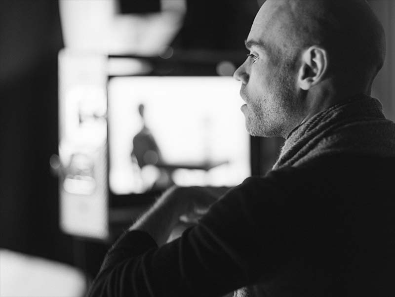 Black and white behind-the-scenes photo of Writer/Director Jody Whittle-Wyeth focused in thought while directing the You Were Perfect teaser in a studio setting.